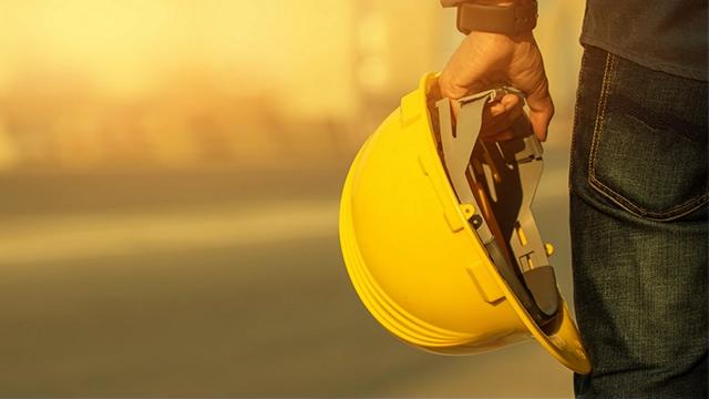 Careers home page image - worker holding a yellow hard hat